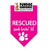 Hot Pink one size fits most dog bandana with Rescued and Lovin it and a paw in white ink.