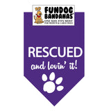 Purple one size fits most dog bandana with Rescued and Lovin it and a paw in white ink.